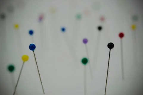 Different coloured pins on a light background Stock Photos