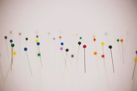 Different coloured pins on a light background Stock Photos