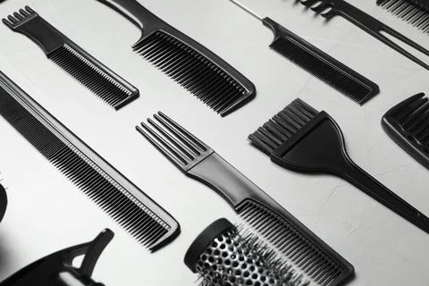 Different combs on light grey stone background, closeup Stock Photos