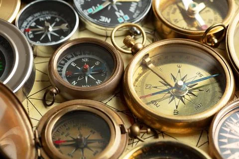 Different compasses on old map Stock Photos