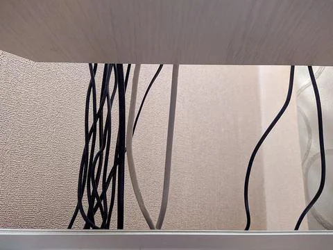 Different computer wires hanging behind the desktop. Foto stock