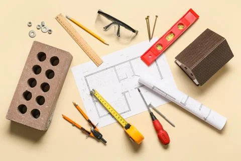 Different construction tools, brick and house plan on beige background Stock Photos