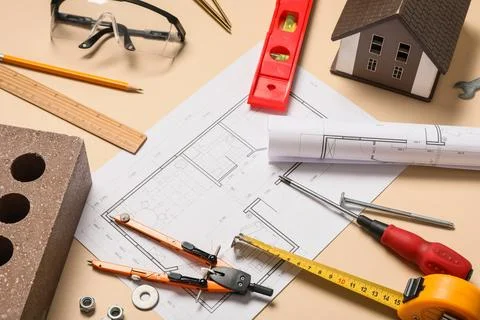 Different construction tools, brick and house plan on beige background Stock Photos