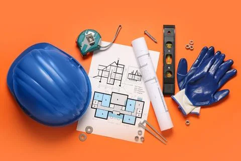 Different construction tools, hardhat and house plan on orange background Stock Photos