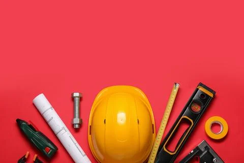 Different construction tools, house plan and hardhat on red background, top v Stock Photos