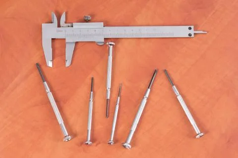 Different construction tools on a wooden background - screwdriver, caliper Stock Photos