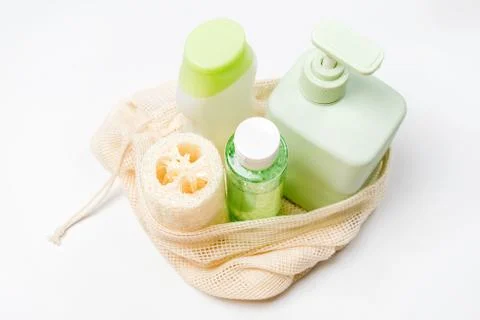 Different containers for shampoo, conditioner, tonic, liquid soap in eco bag. Stock Photos