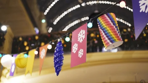 Different decorations hanging on wire with lamps inside department store 動画素材 104552672