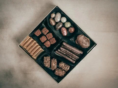 Different delicious chocolate candies on black table, flat lay, top view Stock Photos