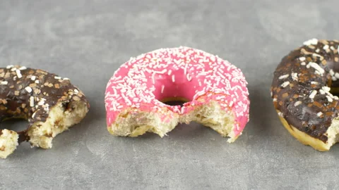 Different delicious colored bites donuts on yellow background Stock Footage 149479595