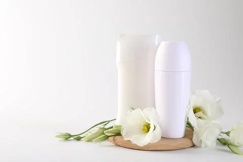 Different deodorants and beautiful eustoma flowers on white background, spa.. 스톡 사진