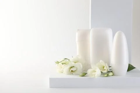 Different deodorants and beautiful eustoma flowers on white background, spa.. 스톡 사진