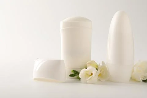 Different deodorants and beautiful eustoma flowers on white background 스톡 사진