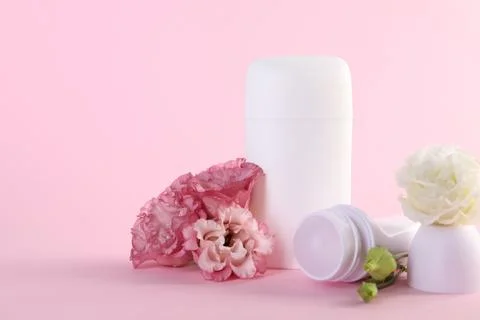 Different deodorants and beautiful eustoma flowers on pink background 스톡 사진