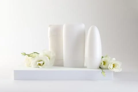 Different deodorants and beautiful eustoma flowers on white background 스톡 사진