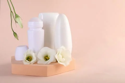 Different deodorants and beautiful eustoma flowers on beige background, spa.. 스톡 사진