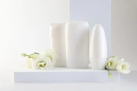 Different deodorants and beautiful eustoma flowers on white background 스톡 사진