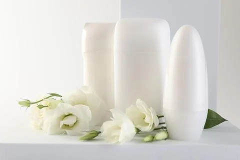 Different deodorants and beautiful eustoma flowers on white background 스톡 사진
