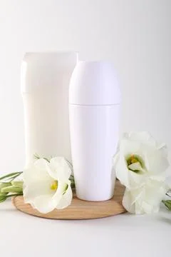 Different deodorants and beautiful eustoma flowers on white background 스톡 사진