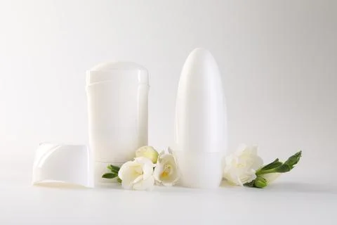 Different deodorants and beautiful eustoma flowers on white background 스톡 사진