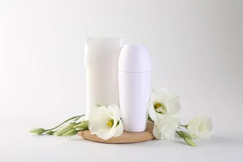 Different deodorants and beautiful eustoma flowers on white background 스톡 사진