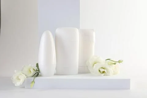 Different deodorants and beautiful eustoma flowers on white background 스톡 사진