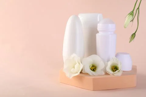 Different deodorants and beautiful eustoma flowers on beige background, spa.. 스톡 사진