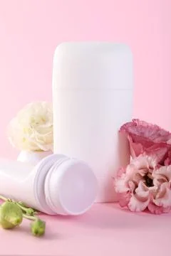 Different deodorants and beautiful eustoma flowers on pink background 스톡 사진