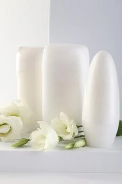 Different deodorants and beautiful eustoma flowers on white background 스톡 사진