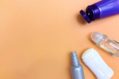 Different deodorants on beige background. Stock Photos