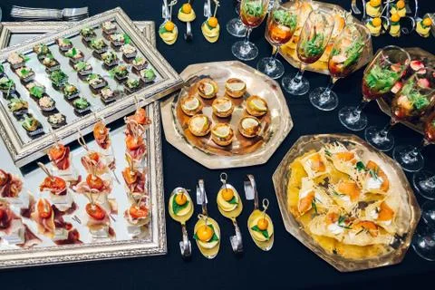 Different desserts in plates on a black table Stock Photos