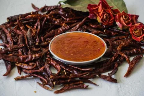 Different dried chilli pods in place with cooked sauce. Stock Photos