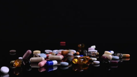 Different drugs falling on black background Stock Footage 170621172
