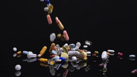 Different drugs falling on black background Stock Footage 231417228