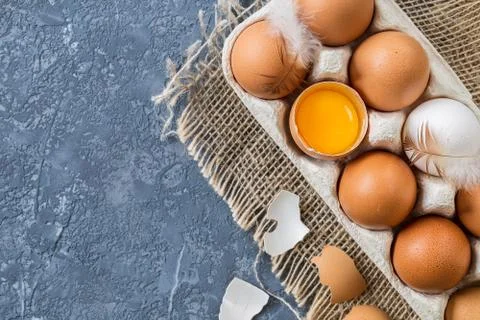 Different eggs in carton pack  on dark stone table. Stock Photos