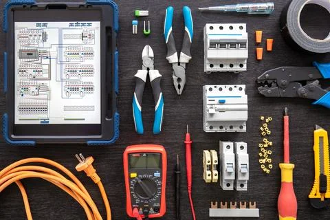 Different electrical tools on wooden background, flat lay. Stock Photos