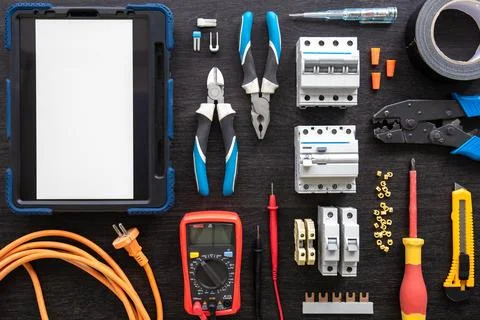 Different electrical tools on wooden background, flat lay. Stock Photos