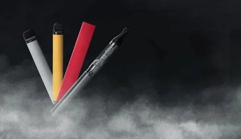 Different electronic smoking devices on black background. Space for text Stock Photos