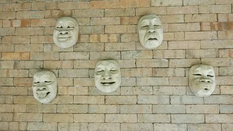 Different expression mask on the wall 01 Foto stock