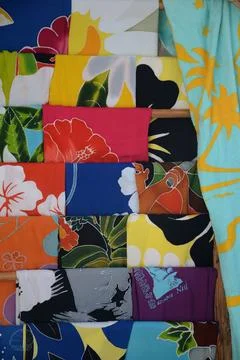 Different fabrics and their multicolored prints hanging on a street coat rack Stock Photos