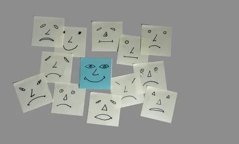 Different Faces Drawn on Paper Notes Surround a Smiling Face in the Center .. 스톡 사진