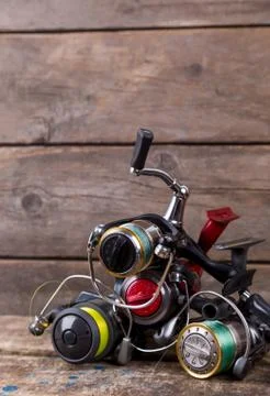 Different fishing reels with line on wooden background Stock Photos