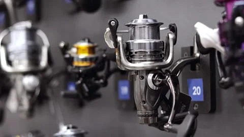 Different fishing rods reels with coils in the fishing store shelf. Close up. Stock Footage 321310853