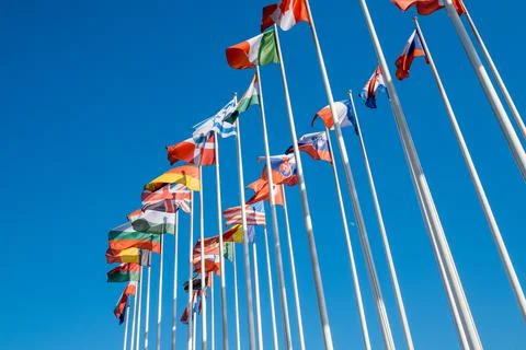 Different flags fluttering on flagpoles Stock Photos