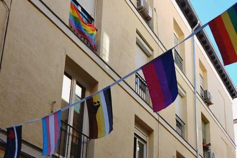 Different flags representing LGBTQI community hang between buildings in Chu.. Stock Photos