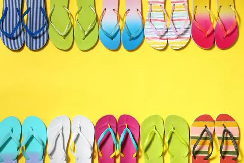 Different flip flops and space for text on yellow background, flat lay. Summe Stock-Fotos