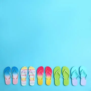 Different flip flops and space for text on blue background, flat lay. Summer  Stock-Fotos