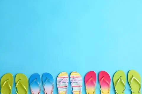 Different flip flops and space for text on blue background, flat lay. Summer  Stock-Fotos