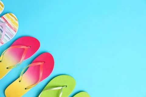 Different flip flops and space for text on blue background, flat lay. Summer  Stock-Fotos