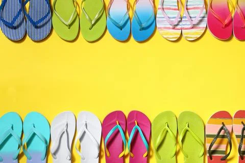Different flip flops and space for text on yellow background, flat lay. Summe Stock Photos